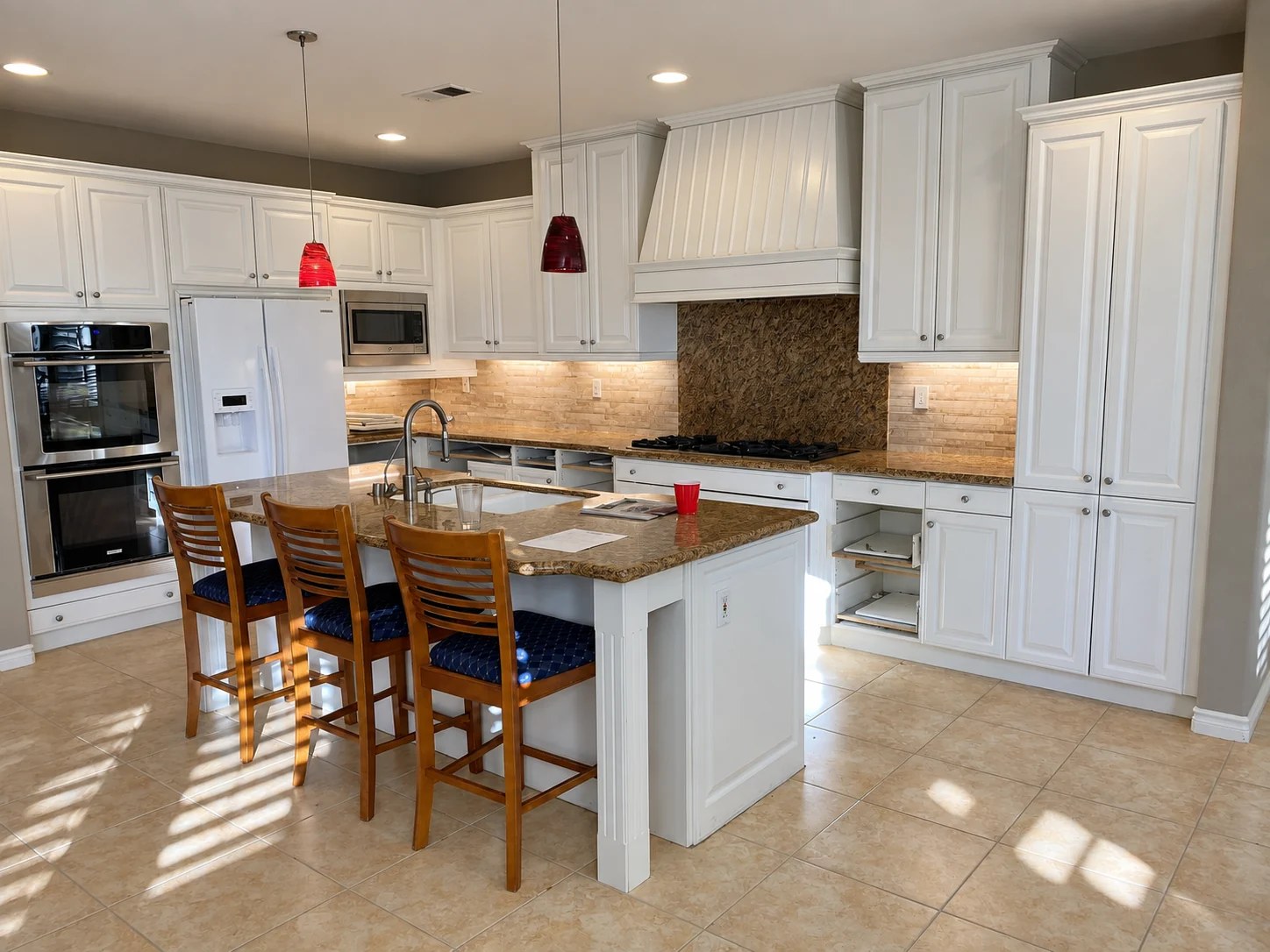 Novak kitchen before remodeling, with white cabinetry and brown stone counters